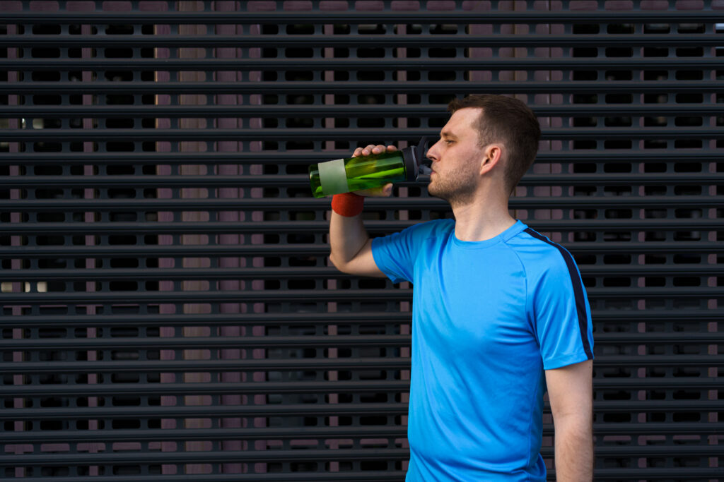caucasian man drinking water during exercises