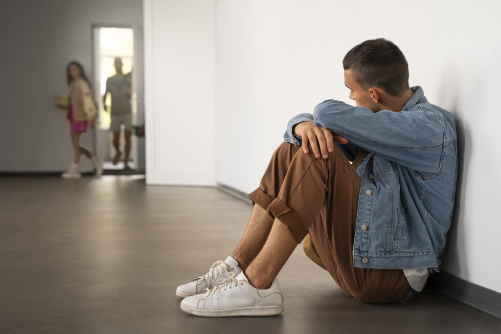 side view sad boy sitting floor (2)